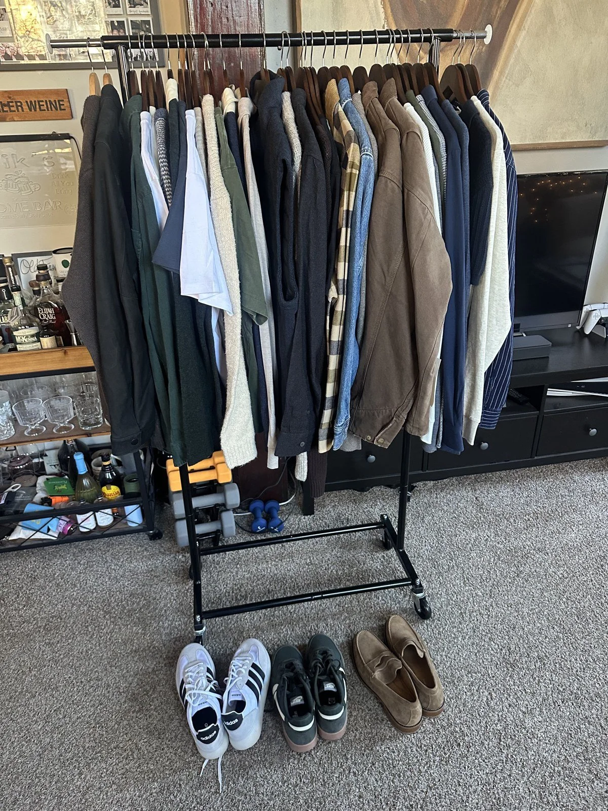 Selected shirts, jackets and shoes arranged on a clothing rack