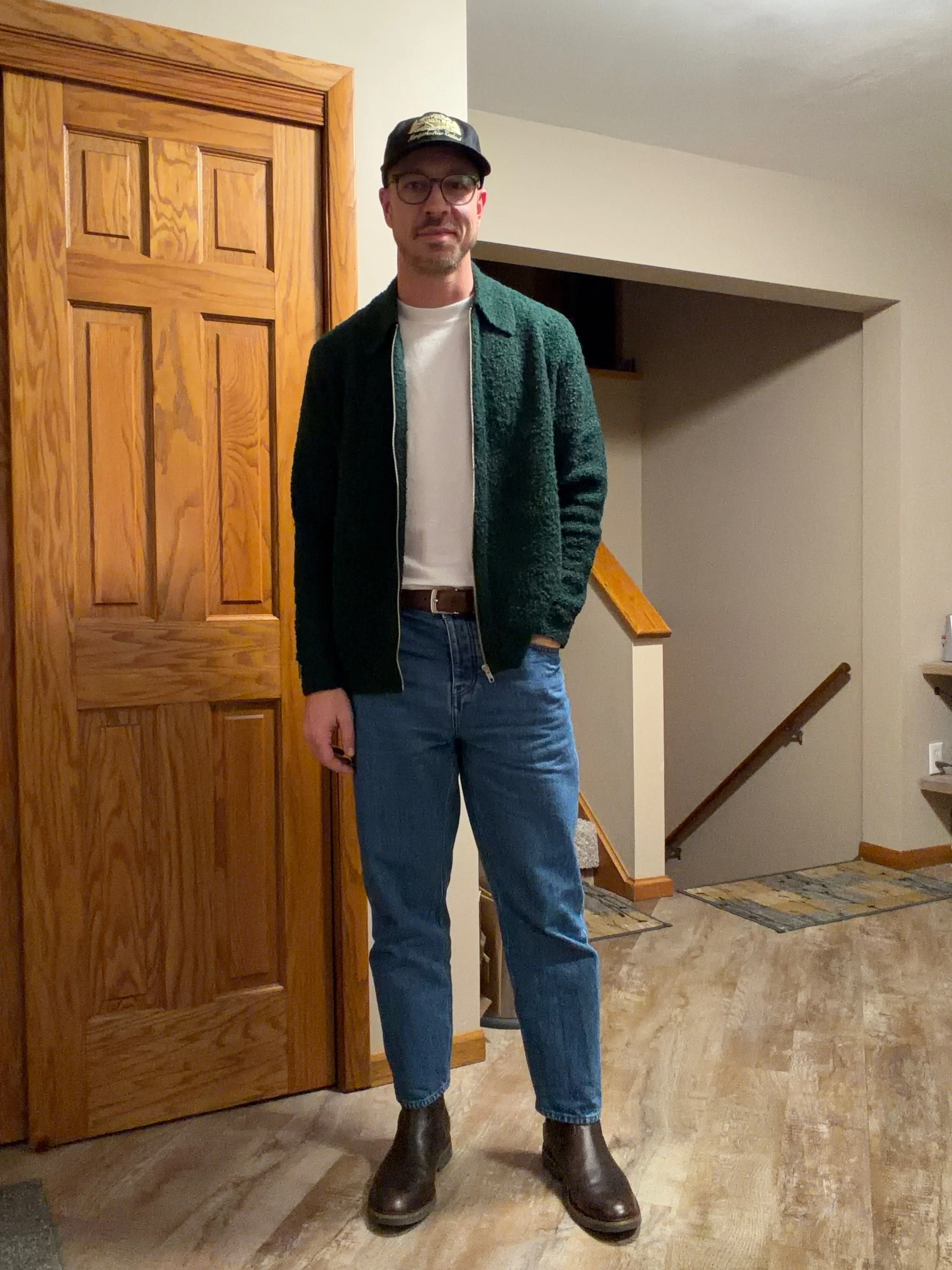 Green jacket with light denim and brown boots