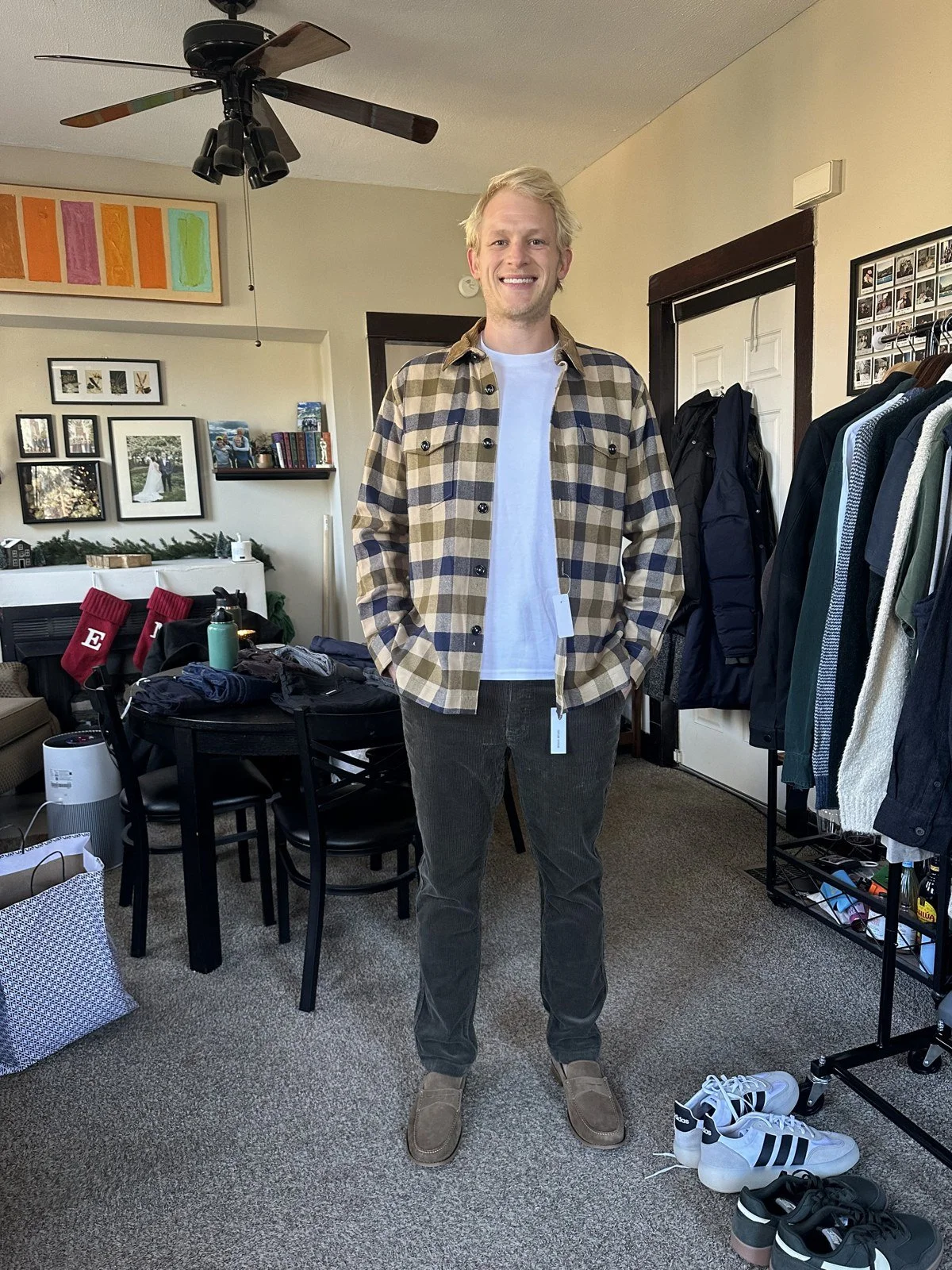 Client wearing a checked overshirt over a white shirt with gray trousers