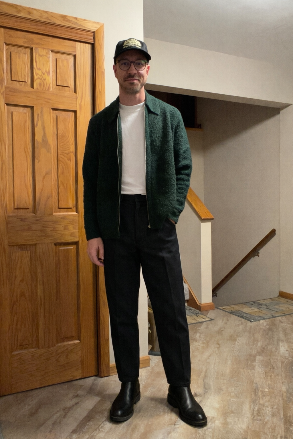 Green textured jacket with black trousers and boots