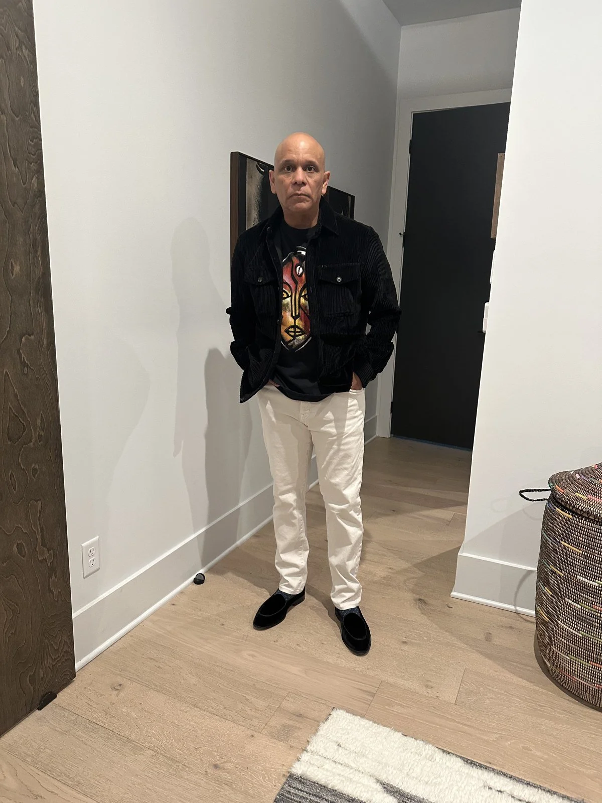 Black jacket and graphic tee styled with cream trousers