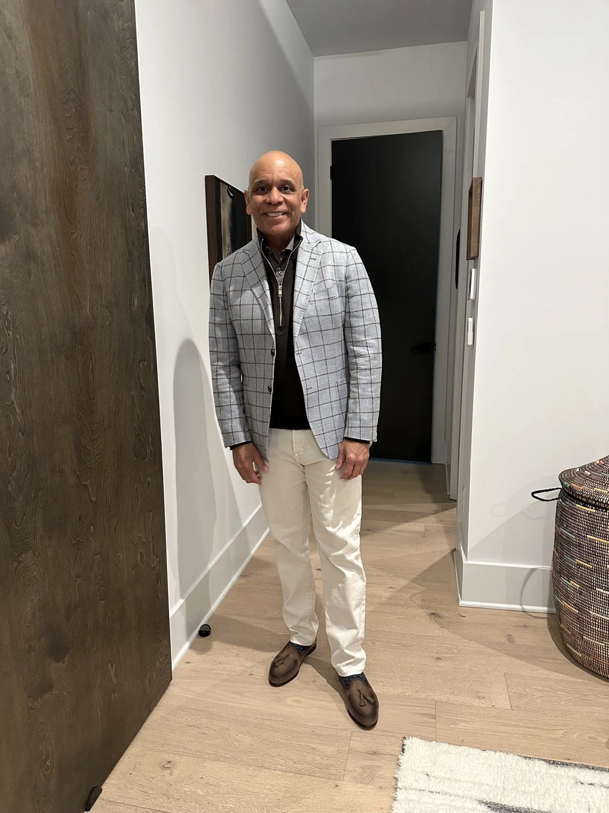 Client styled in a gray checked blazer and dark trousers