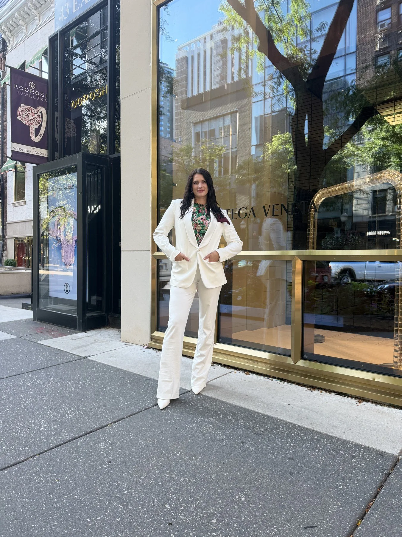 Jax wearing a white suit outside a storefront