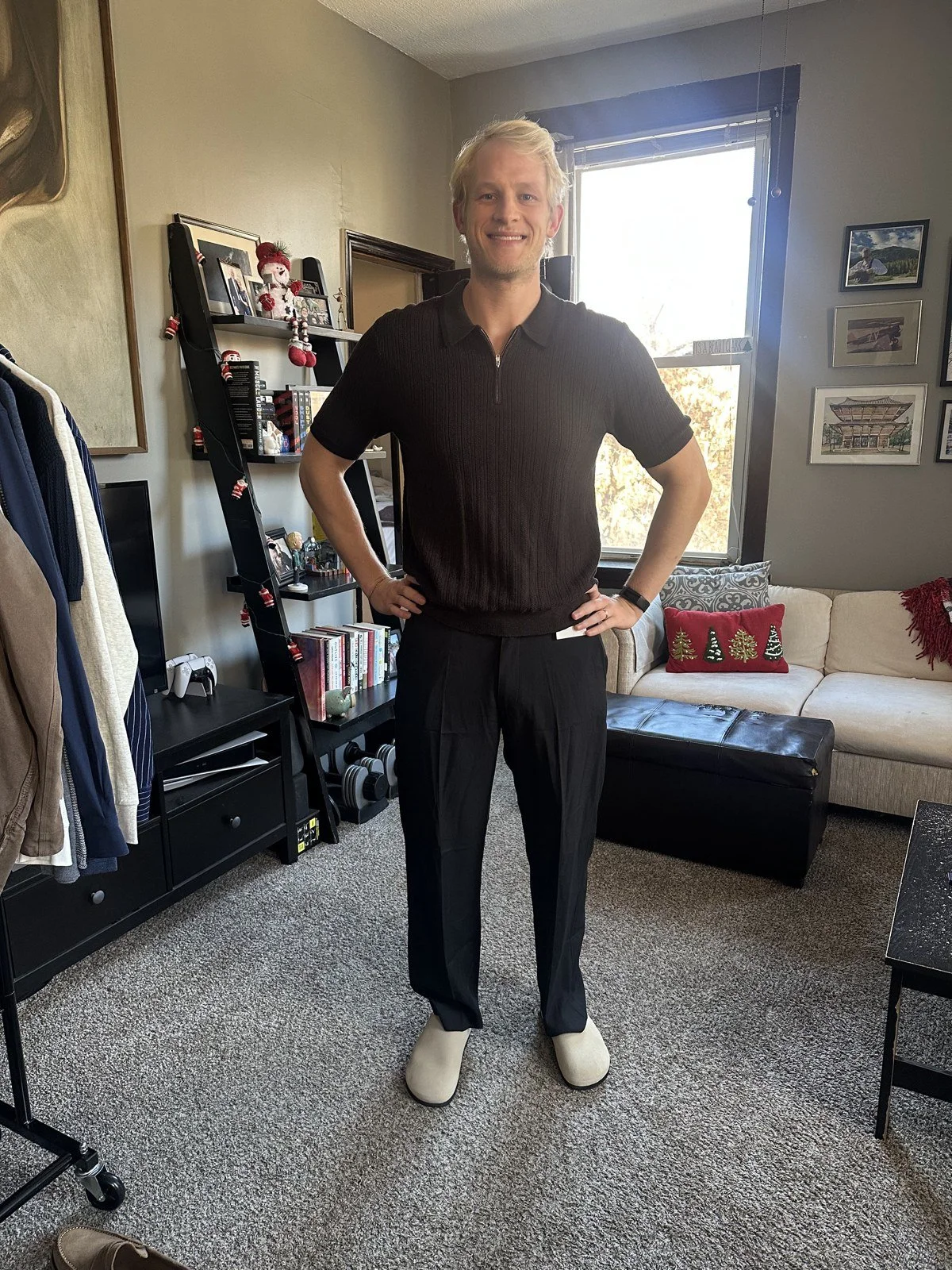 Client wearing a dark polo, black trousers and cream shoes