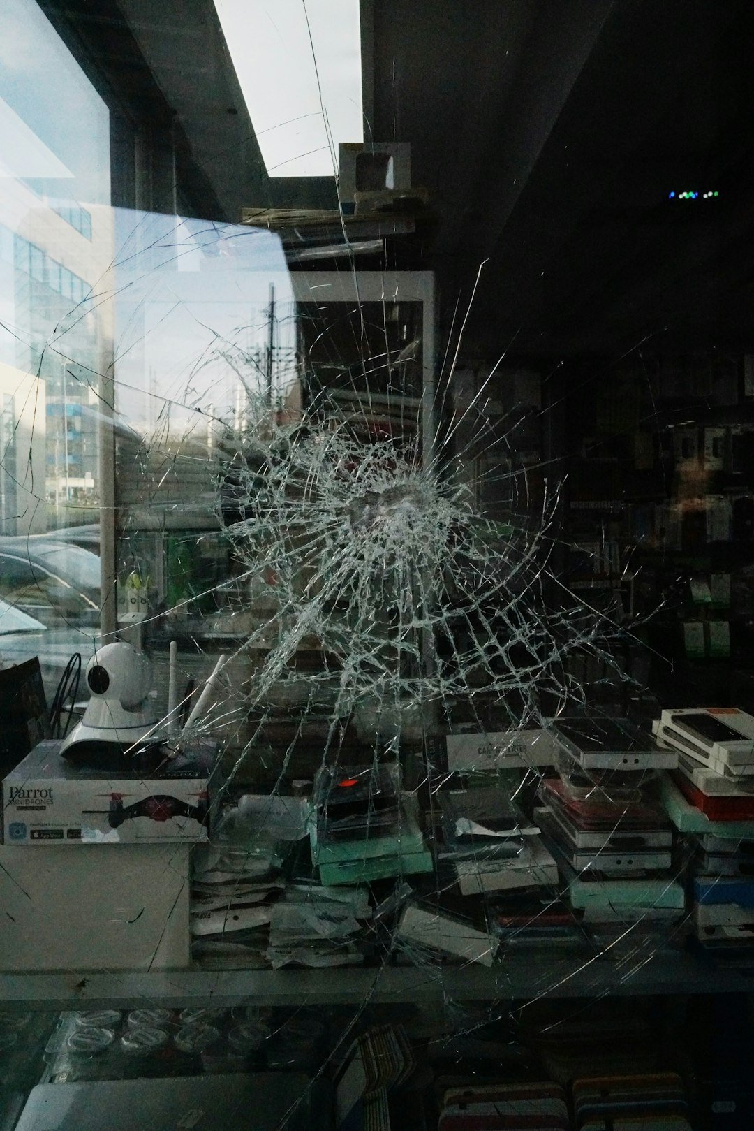 dark storefront window shattered overnight with debris