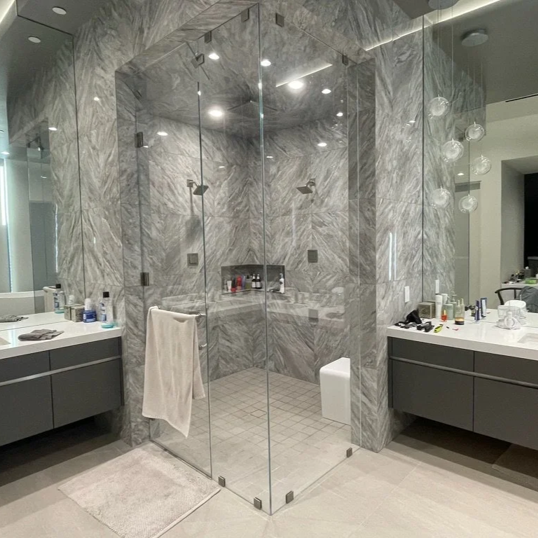 modern frameless shower door installed in tile bathroom