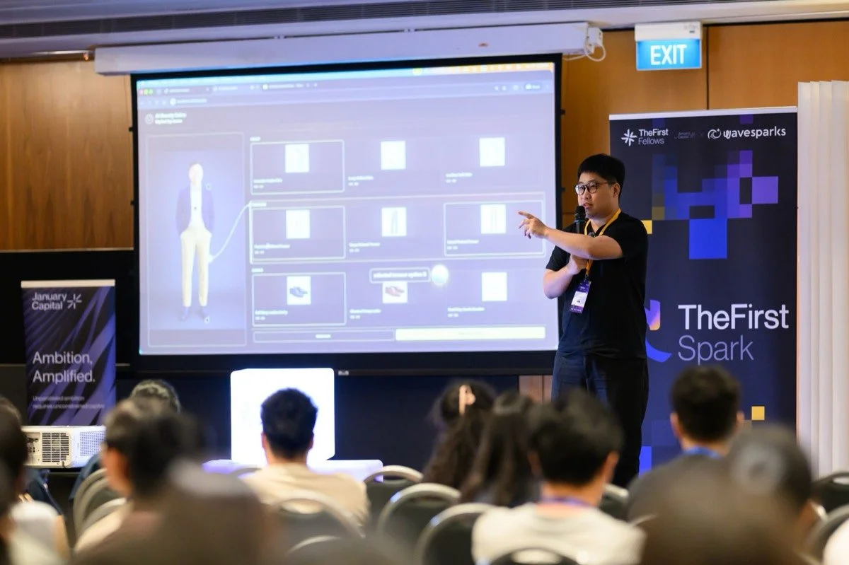 A speaker demonstrates an AI product to TheFirst Spark audience