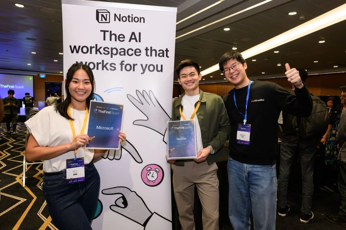Attendees and partners pose beside the Notion booth