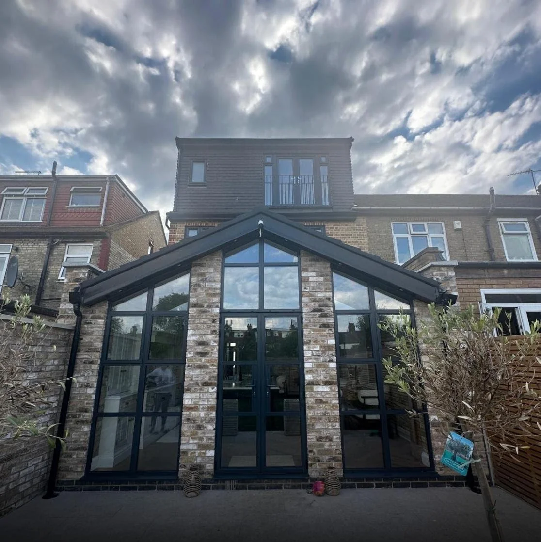 Rear extension with full-height glazing and dormer loft conversion on a London terrace, E4 London. Designed by Bashkal.