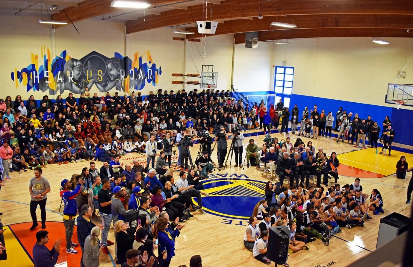Large group of young people and community members gathered inside The Club