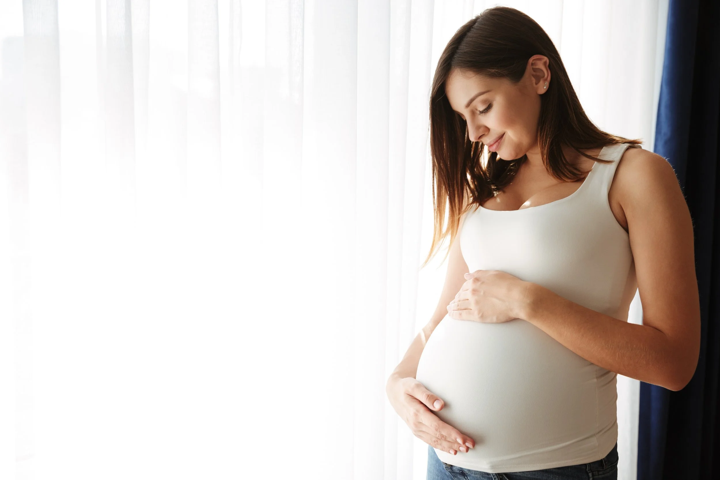 Expecting mother resting a hand on her belly