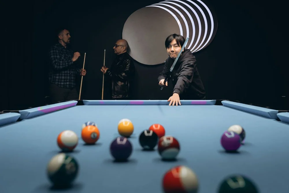 Player lining up a shot in a game of 8-ball, Aramith Tournament balls on Simonis 860HR tournament blue cloth, Rasson 9ft table, Pool Lab Etobicoke