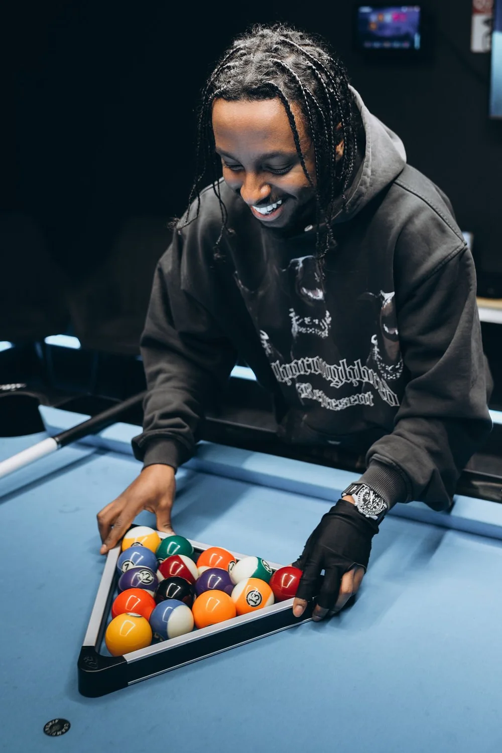 Player racking Aramith Tournament balls in a triangle rack for a game of 8-ball on Simonis 860HR tournament blue cloth at Pool Lab