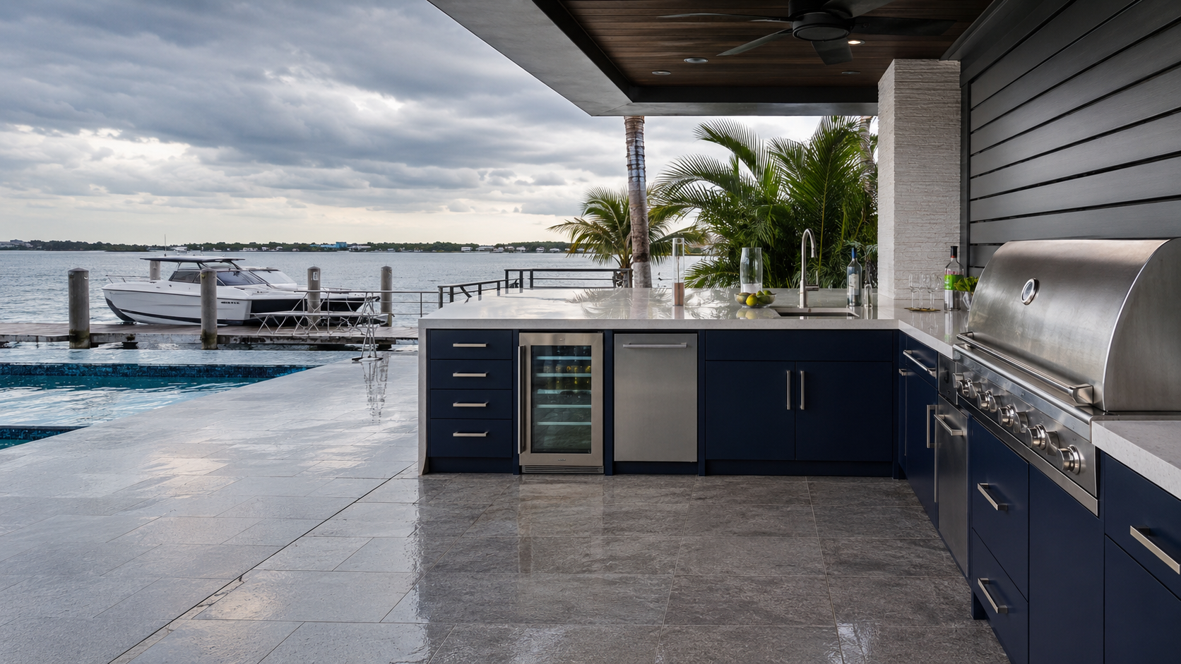 Marine-grade outdoor kitchen cabinetry beside a Florida waterfront pool and dock