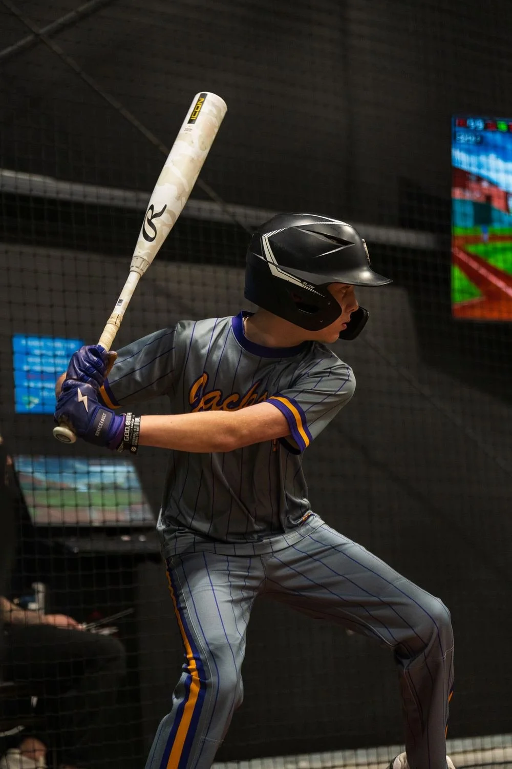 Young hitter mid-swing inside the HitTrax cage at Velocity Sports