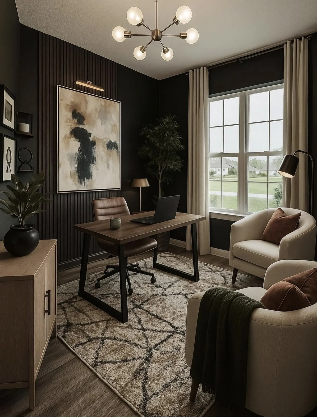 A warm, softly lit study with a wood desk, leather chair, framed abstract art, a tall window and two cream armchairs