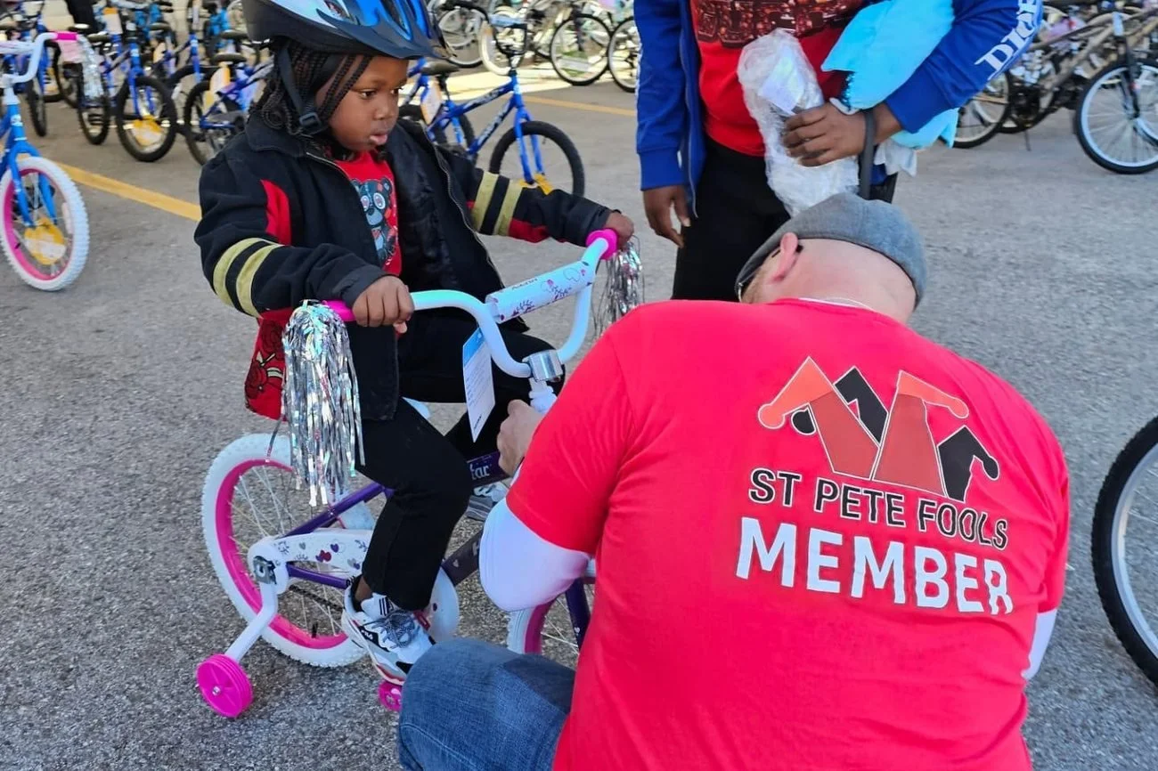 A St. Pete Fools member fits a new bike for a young rider at the December giveaway