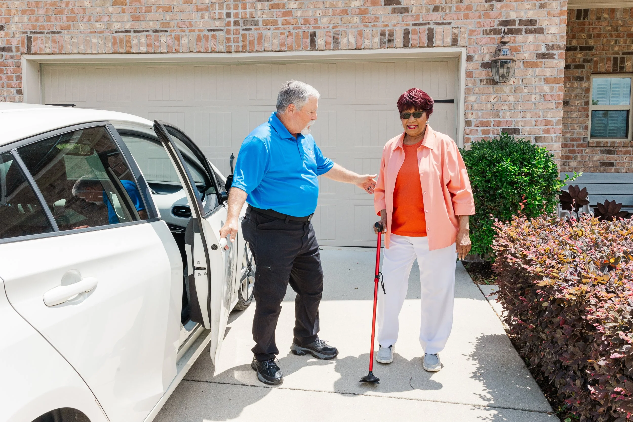 WheelCare driver assisting an ambulatory rider beside a van