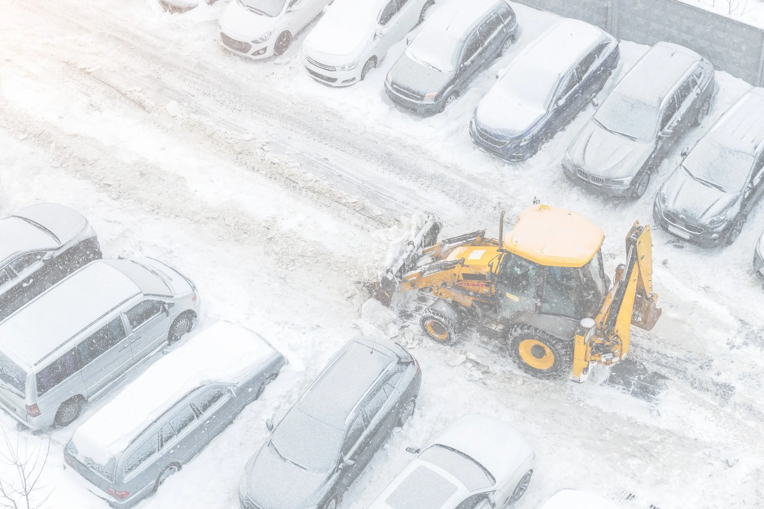 Snow-clearing equipment working in a snow-covered parking area