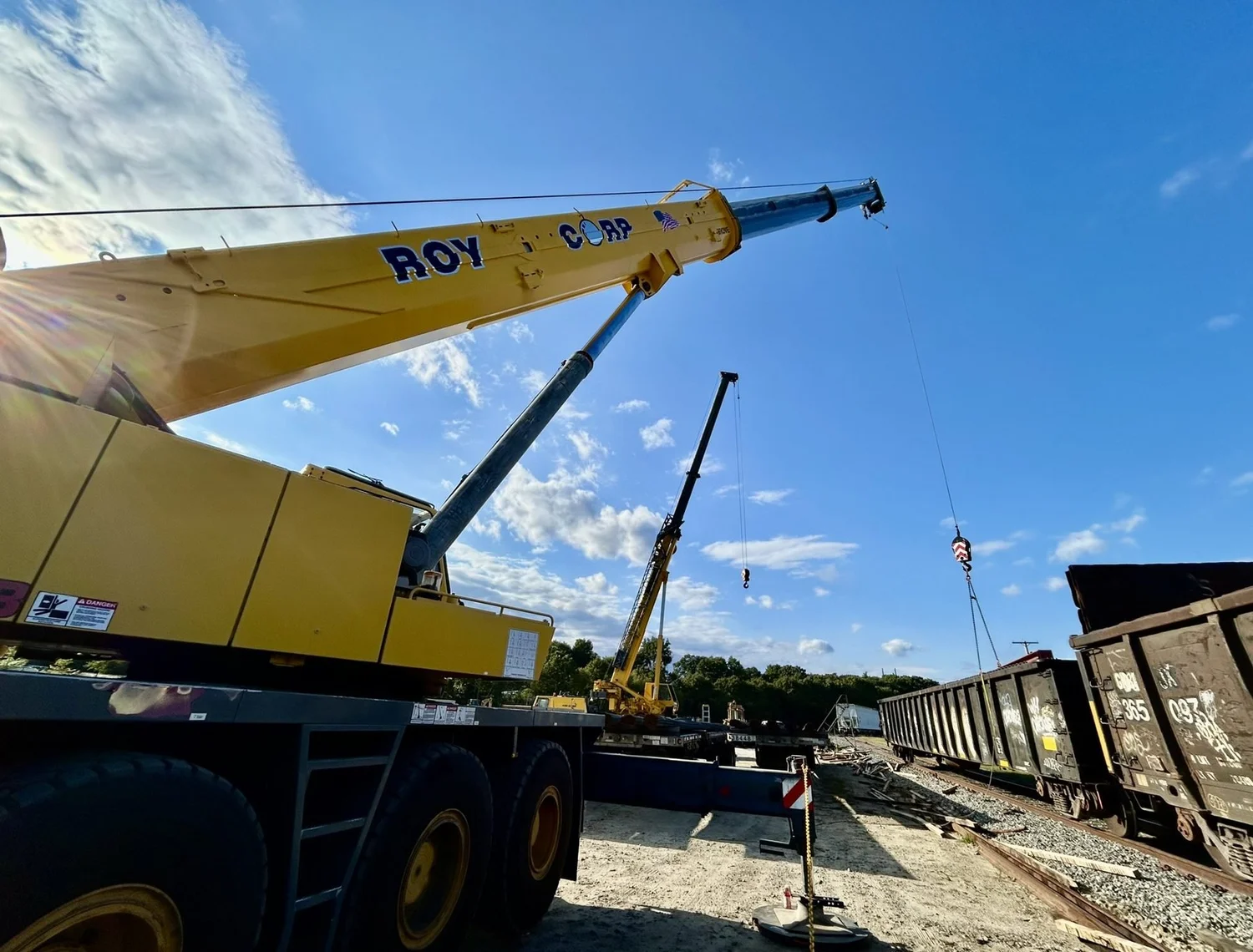 Roy Corp crane beside rail cars at the rail-to-truck transloading yard