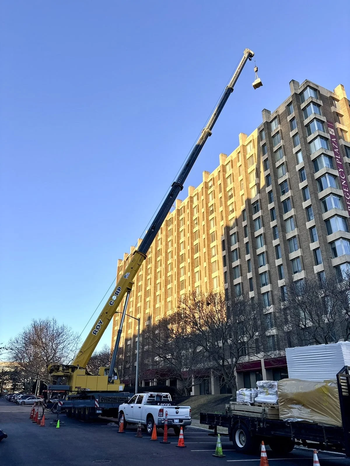 All-terrain crane lifting beside a high-rise building in Providence, RI