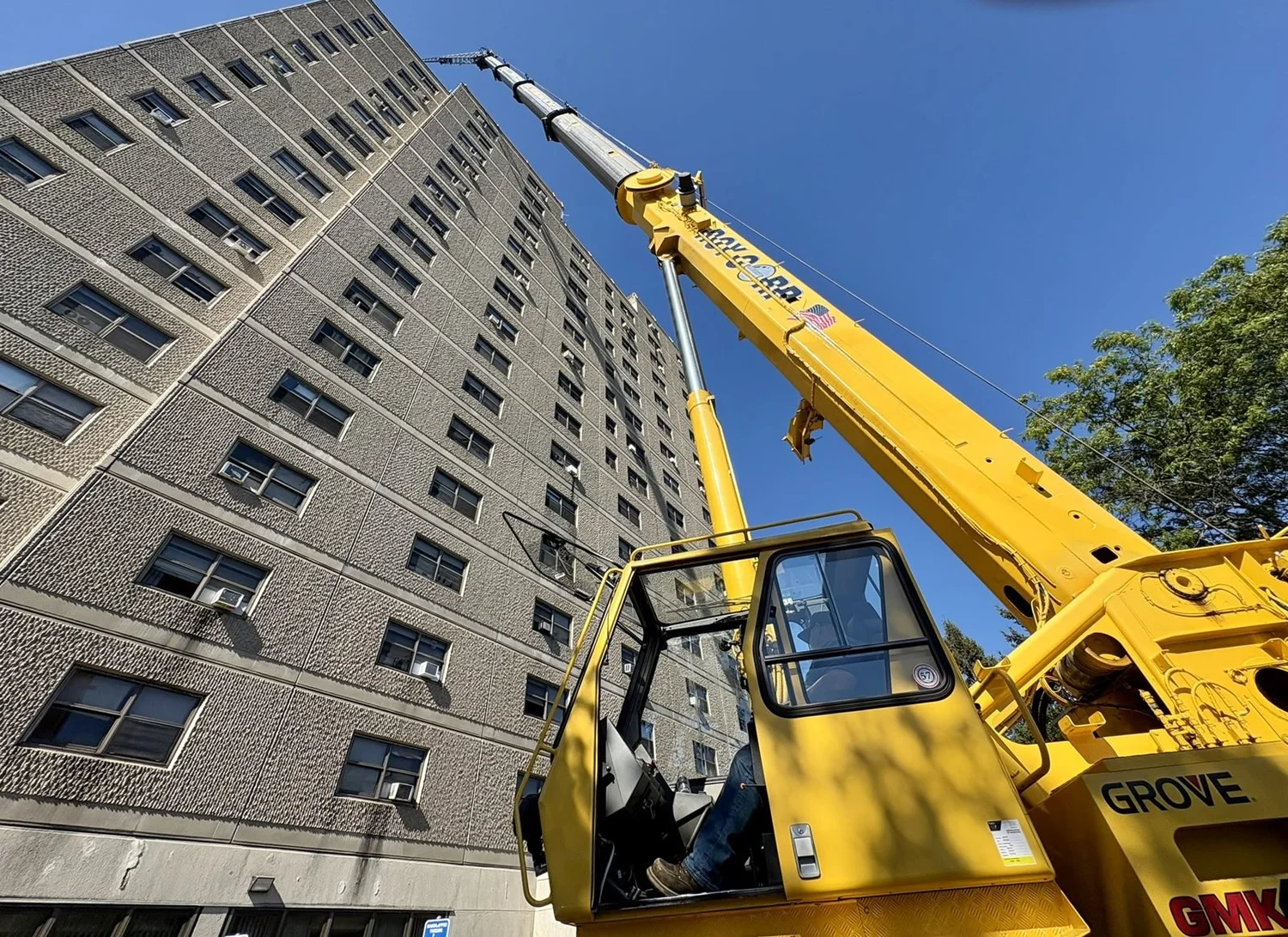 Roy Corp all-terrain crane lifting roofing materials to a high-rise in Providence, RI
