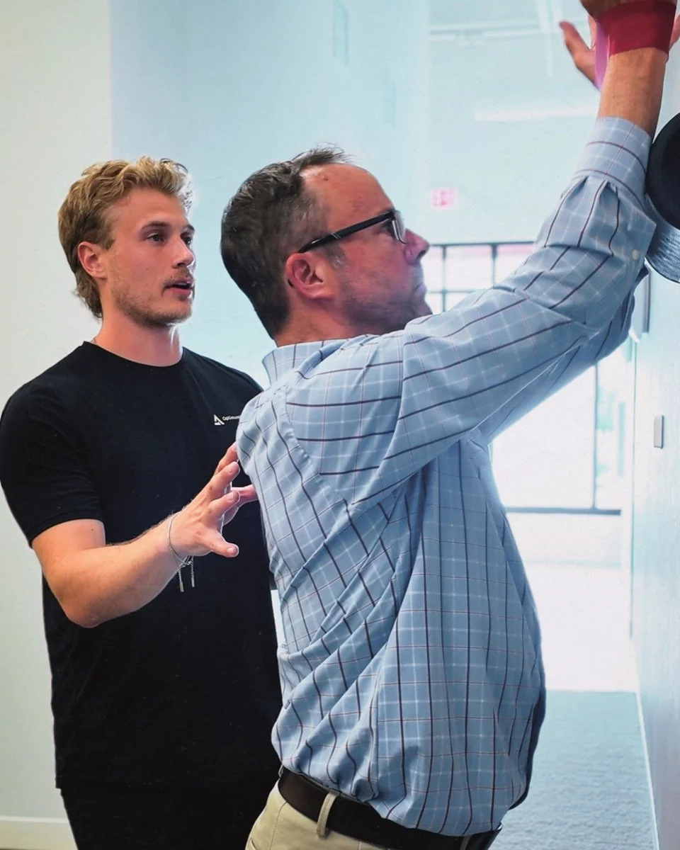Dr. Matt guiding a client through a shoulder mobility exercise
