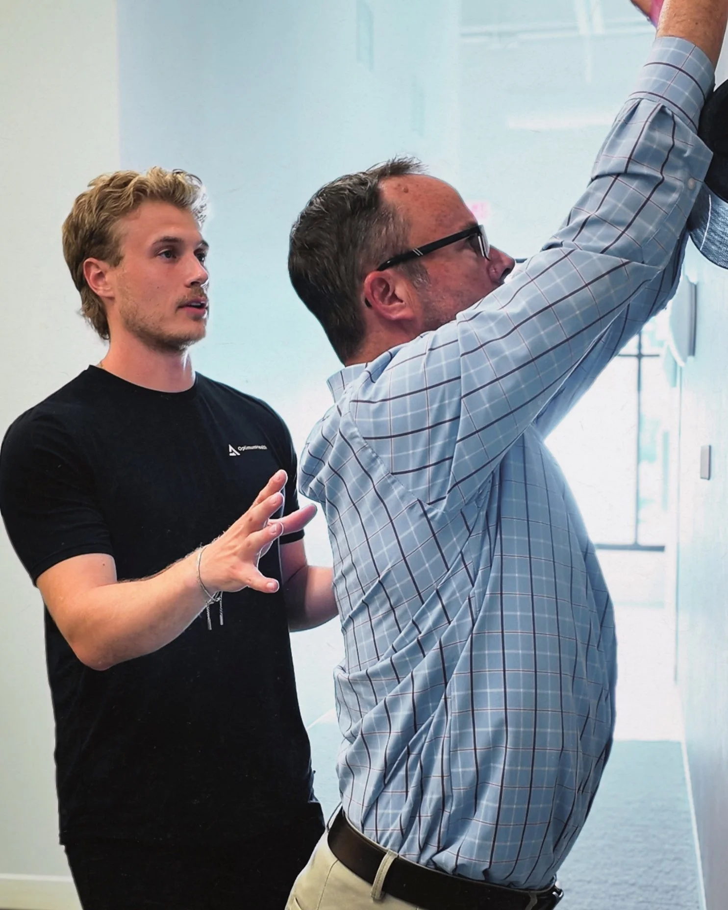 Guided shoulder mobility exercise at Optimum Health