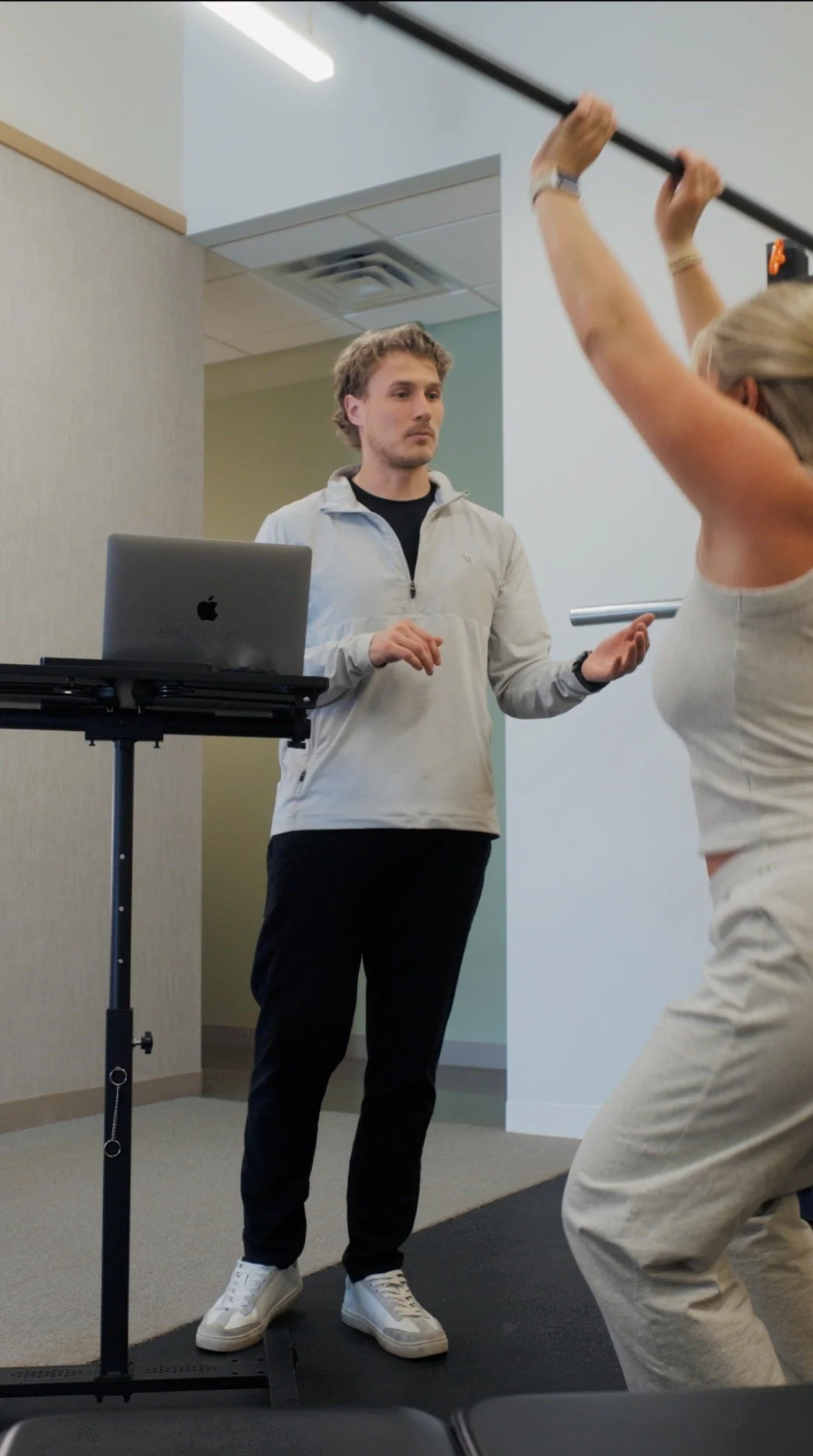 Optimum Health provider guiding a patient through a movement assessment