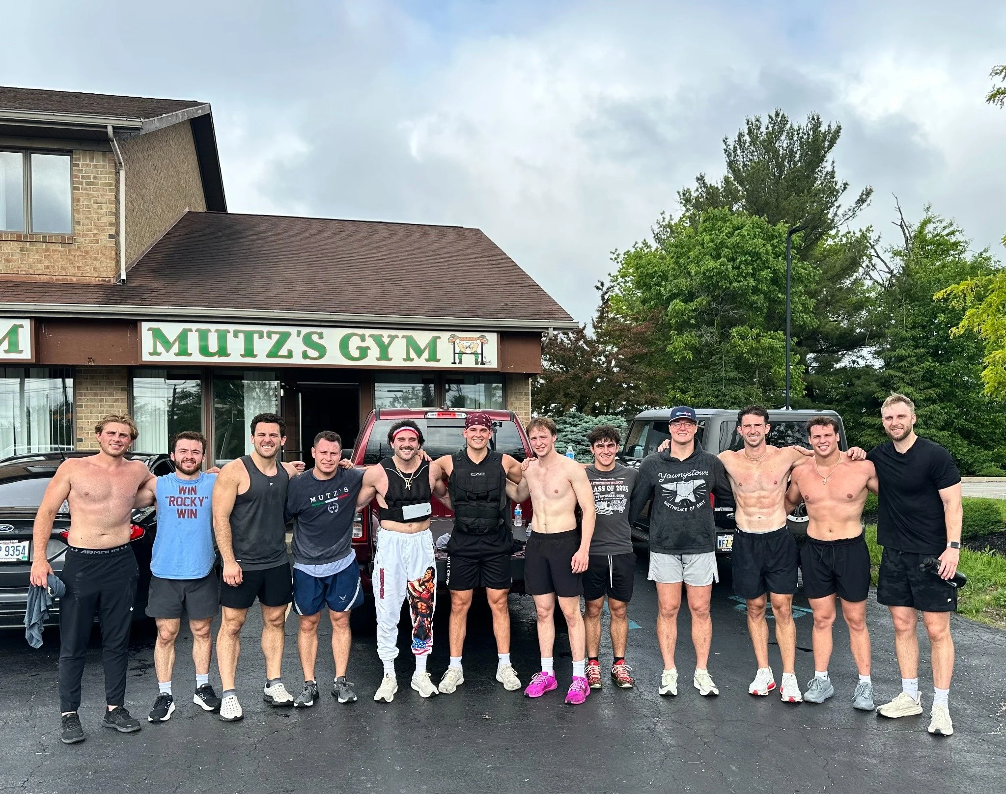 The Mutz’s Gym crew gathered outside beneath the gym sign