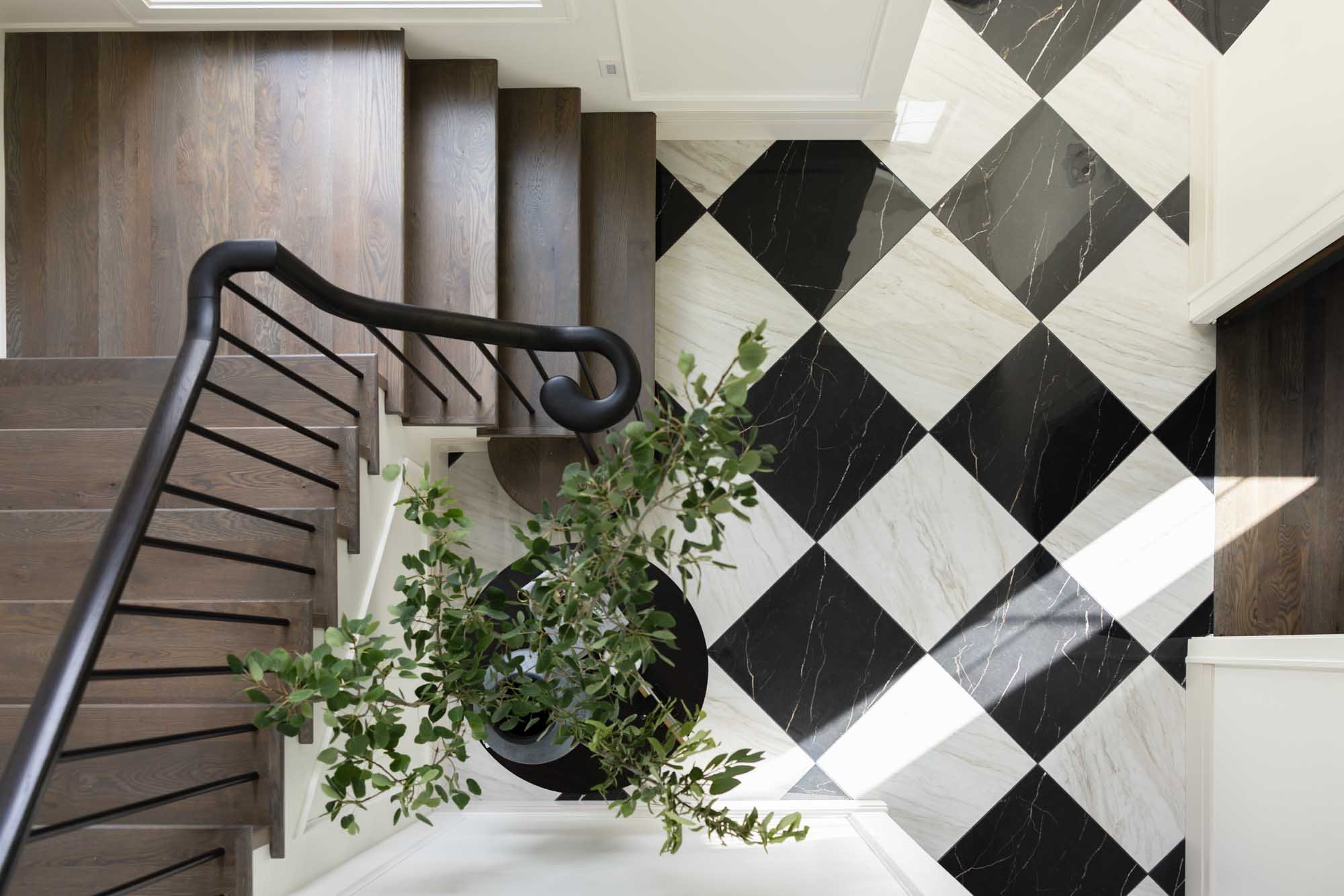 Checkerboard marble entry with a curved iron stair rail