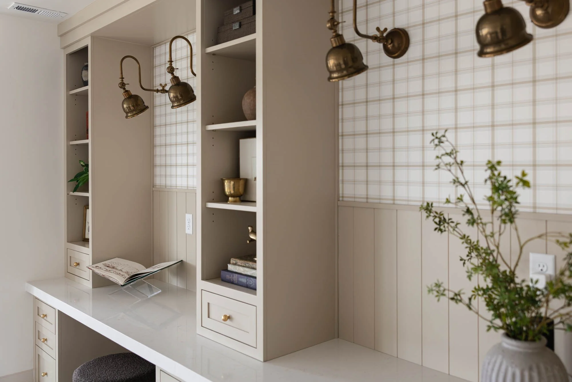 Built-in shelving with brass picture lights