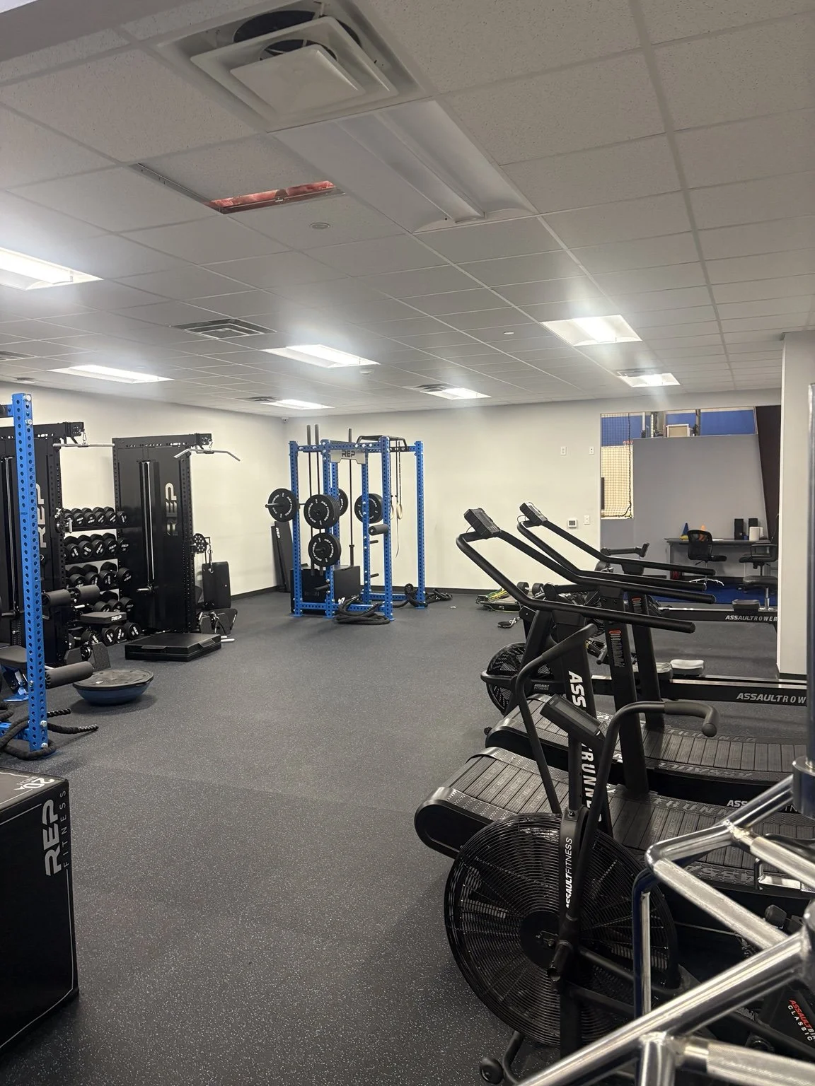 MaxxFIT Katy: Air bikes and curved treadmills alongside the strength area.