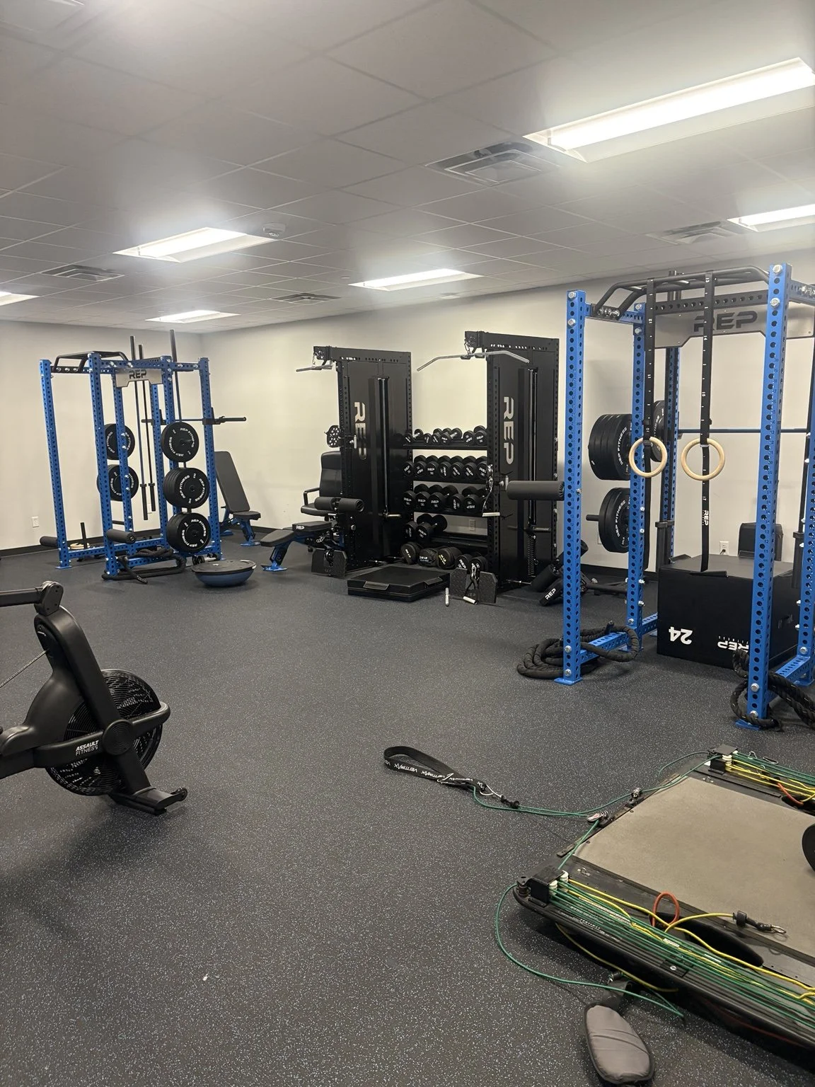 MaxxFIT Katy: Racks, cable stations, dumbbells, and open floor space.