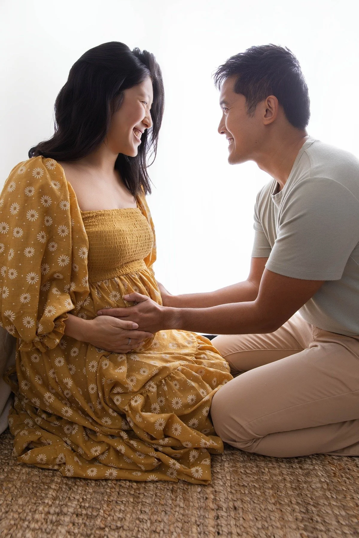 Lifestyle maternity photography in Allen, Texas: couple portrait in a soft neutral studio, photographed by Manal Ansari