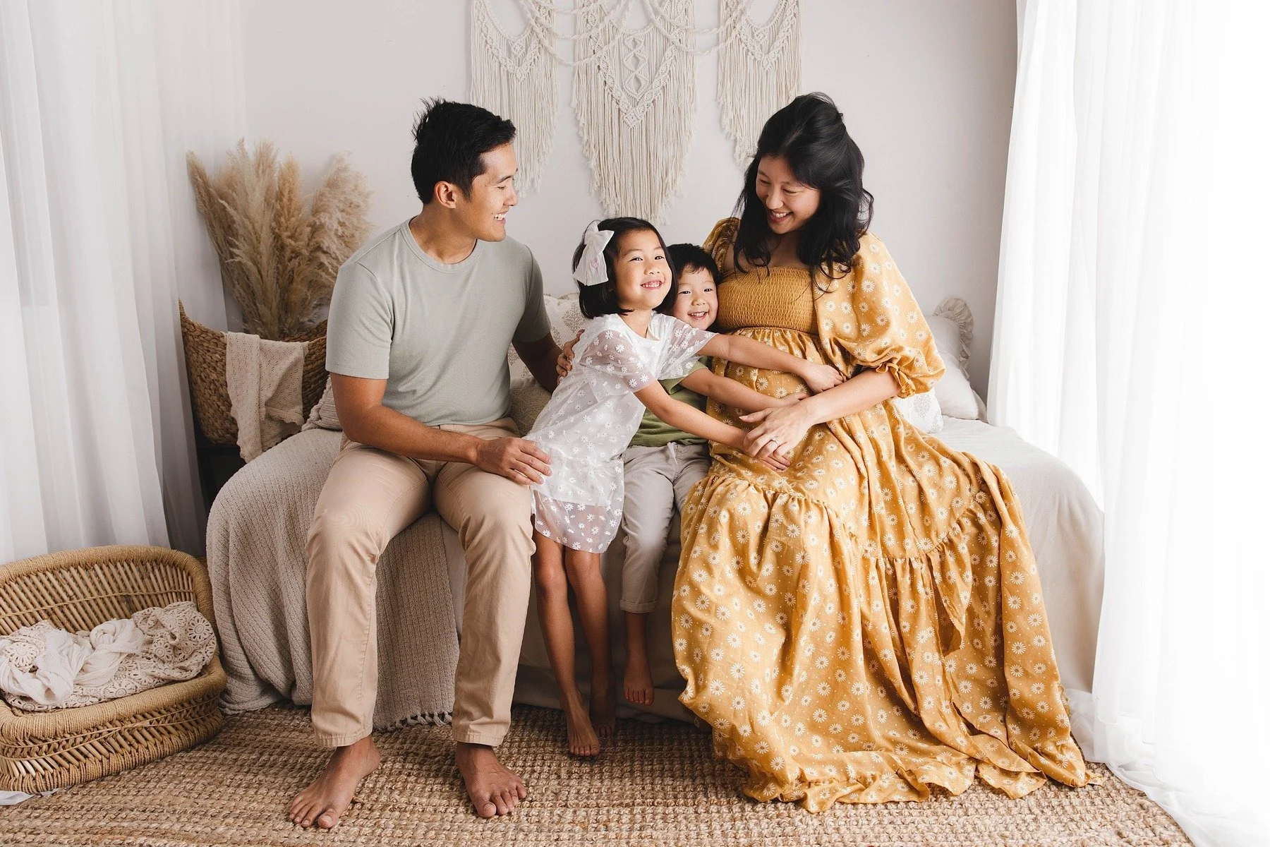Lifestyle maternity photography in Allen, Texas: family portrait in a soft neutral studio, photographed by Manal Ansari