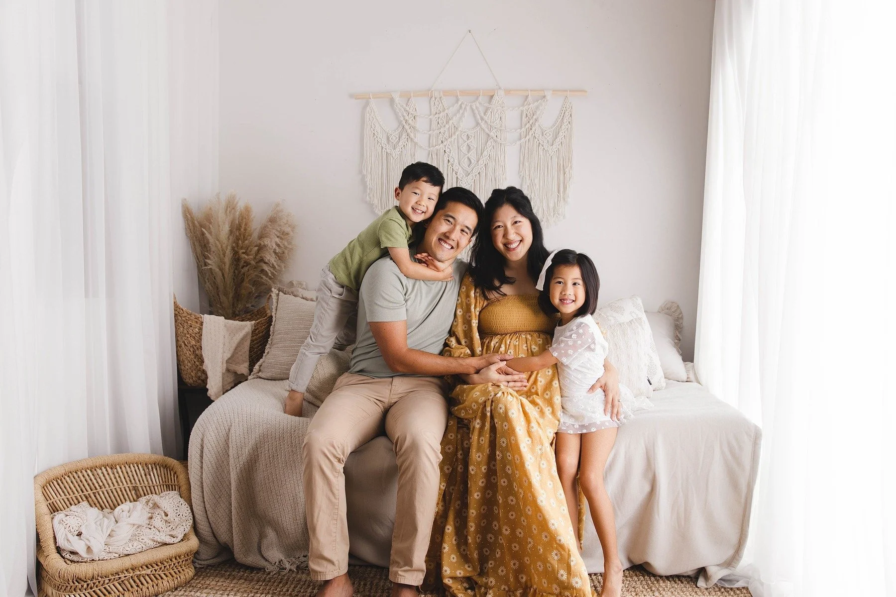 Lifestyle maternity photography in Allen, Texas: family portrait in a soft neutral studio, photographed by Manal Ansari