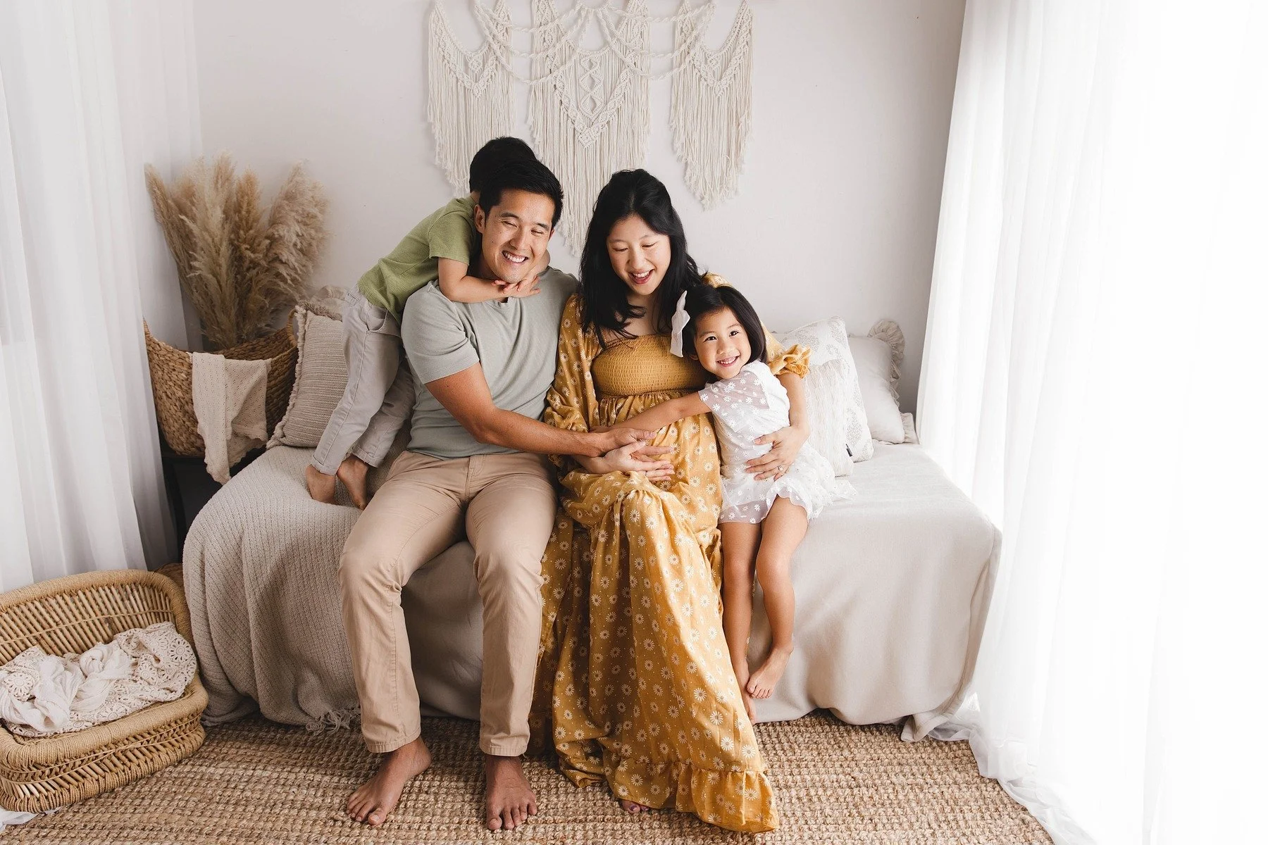 Lifestyle maternity photography in Allen, Texas: family portrait in a soft neutral studio, photographed by Manal Ansari