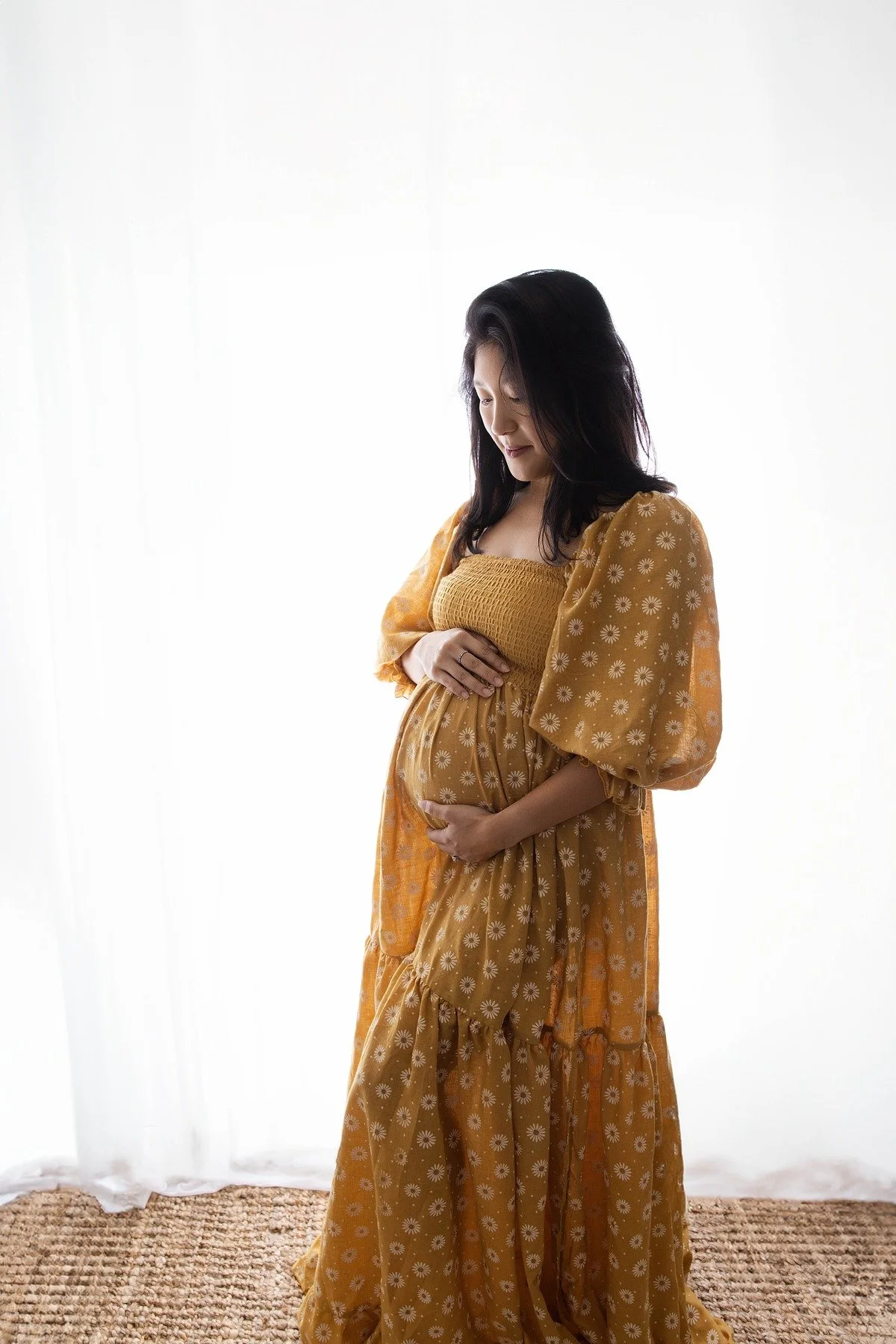 Lifestyle maternity photography in Allen, Texas: solo maternity portrait in a soft neutral studio, photographed by Manal Ansari