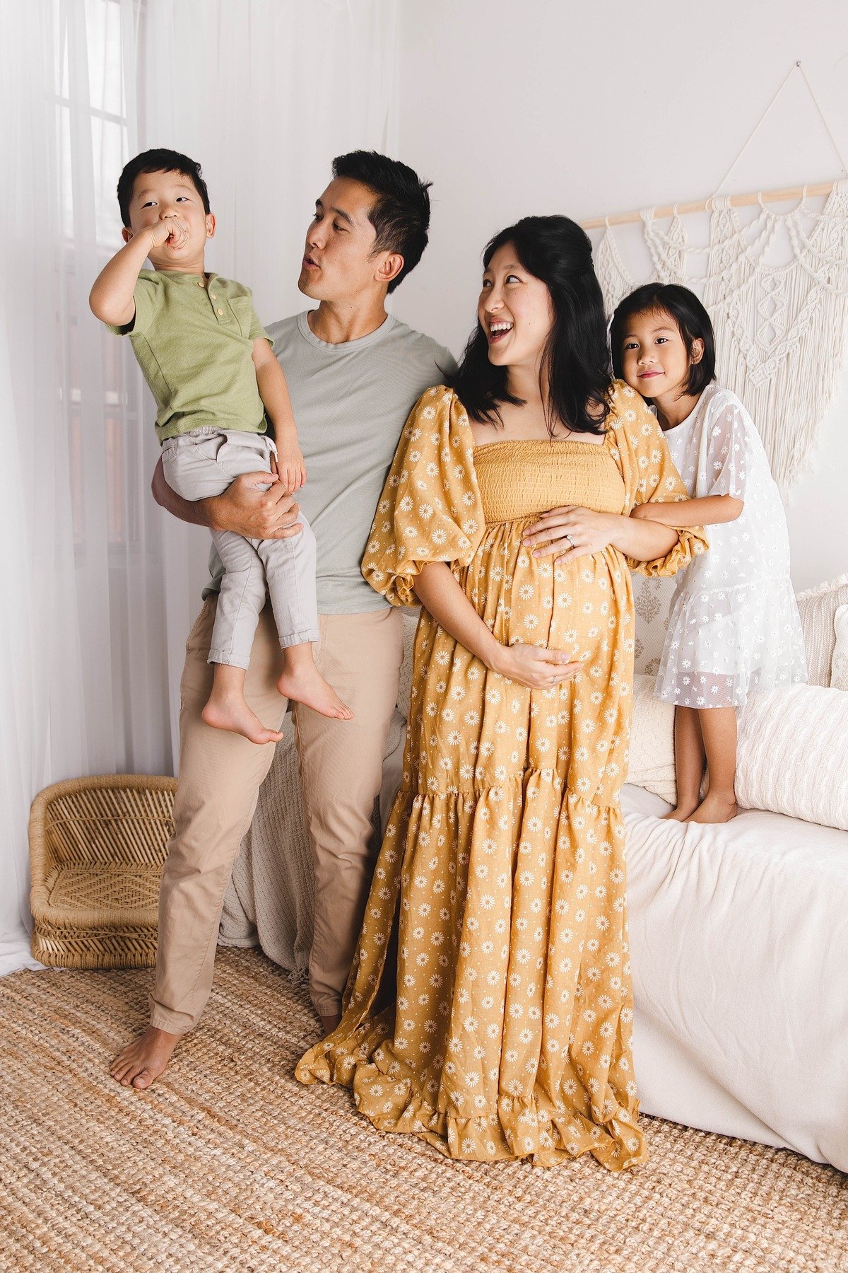 Lifestyle maternity photography in Allen, Texas: family portrait in a soft neutral studio, photographed by Manal Ansari