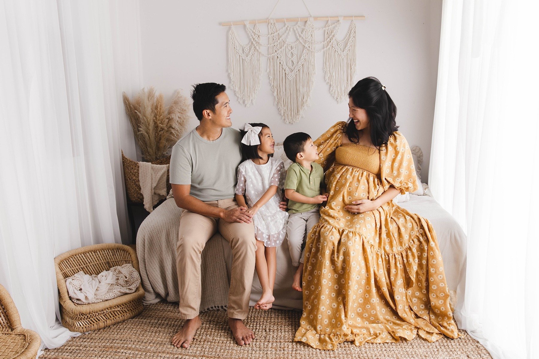 Lifestyle maternity photography in Allen, Texas: family portrait in a soft neutral studio, photographed by Manal Ansari