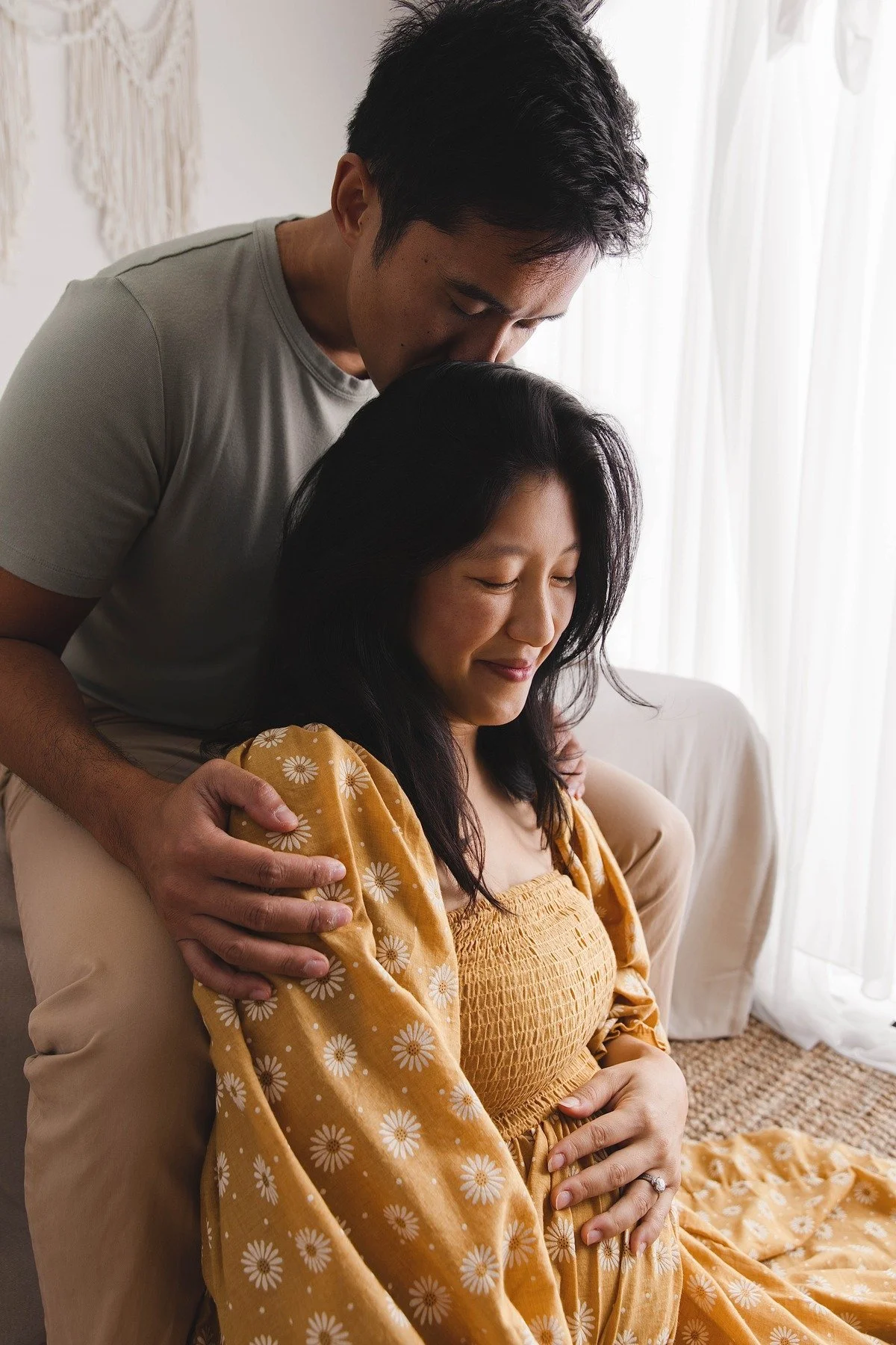 Lifestyle maternity photography in Allen, Texas: couple portrait in a soft neutral studio, photographed by Manal Ansari