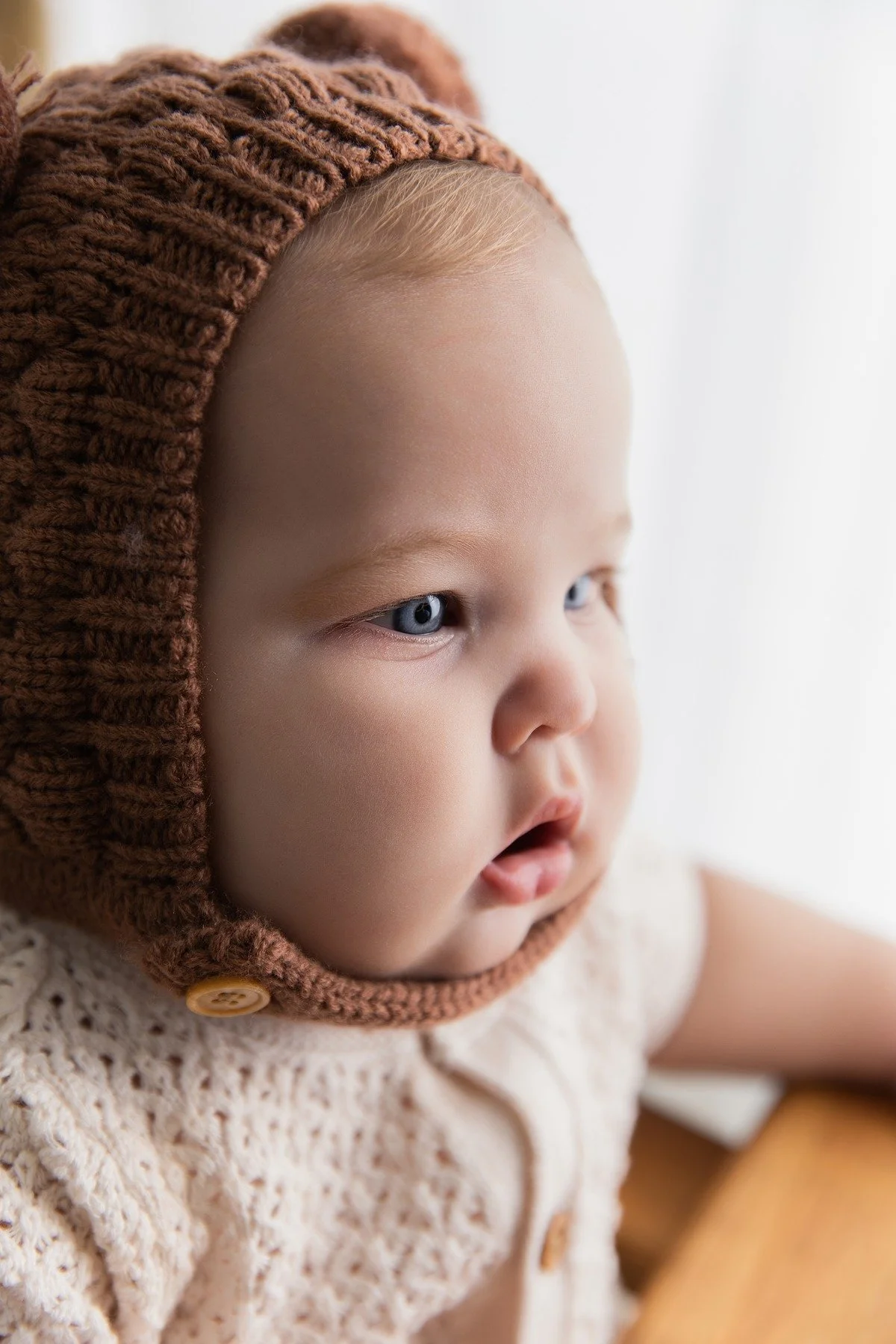 Close-up of Paxton in a brown knitted bear bonnet