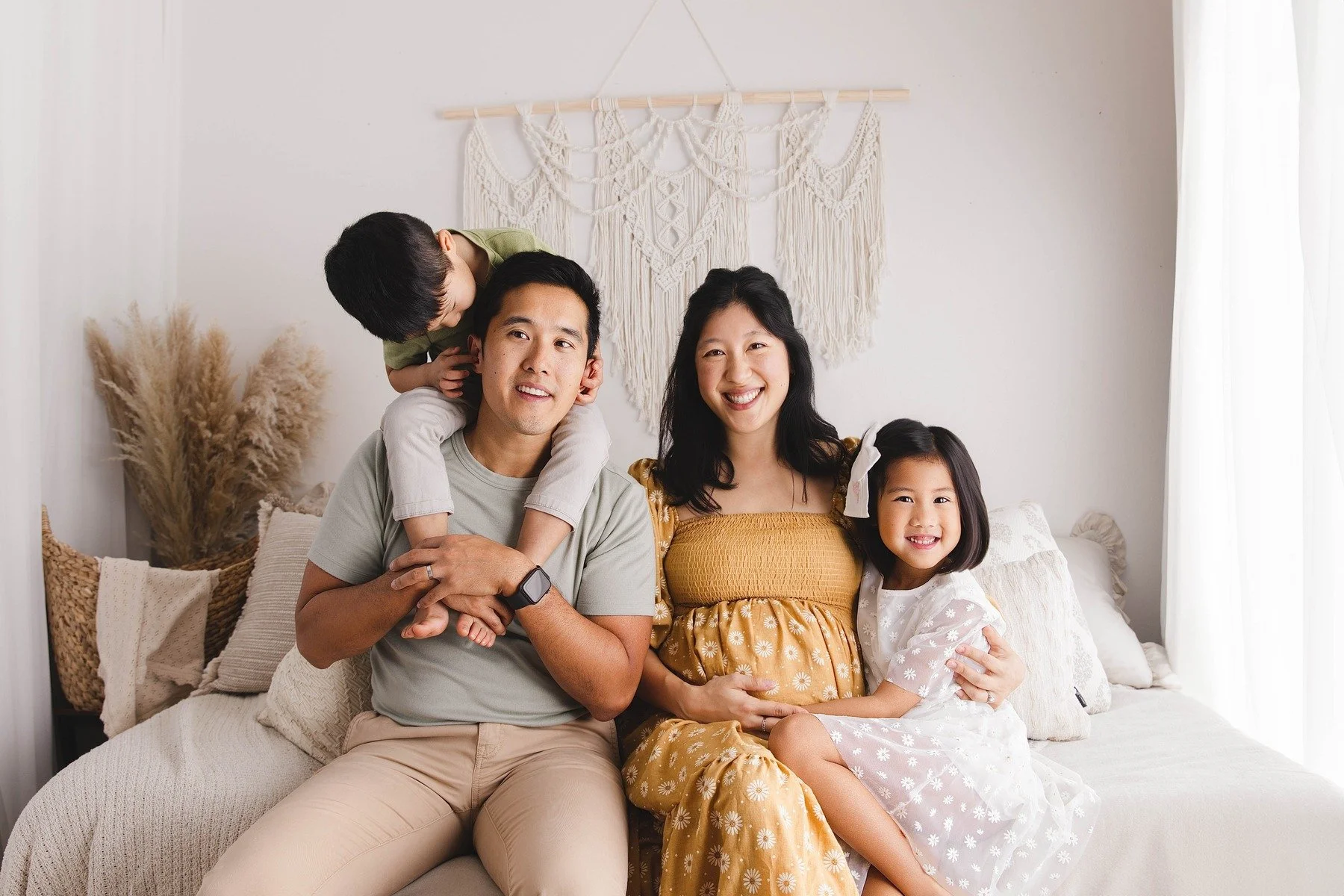 Lifestyle maternity photography in Allen, Texas: family portrait in a soft neutral studio, photographed by Manal Ansari