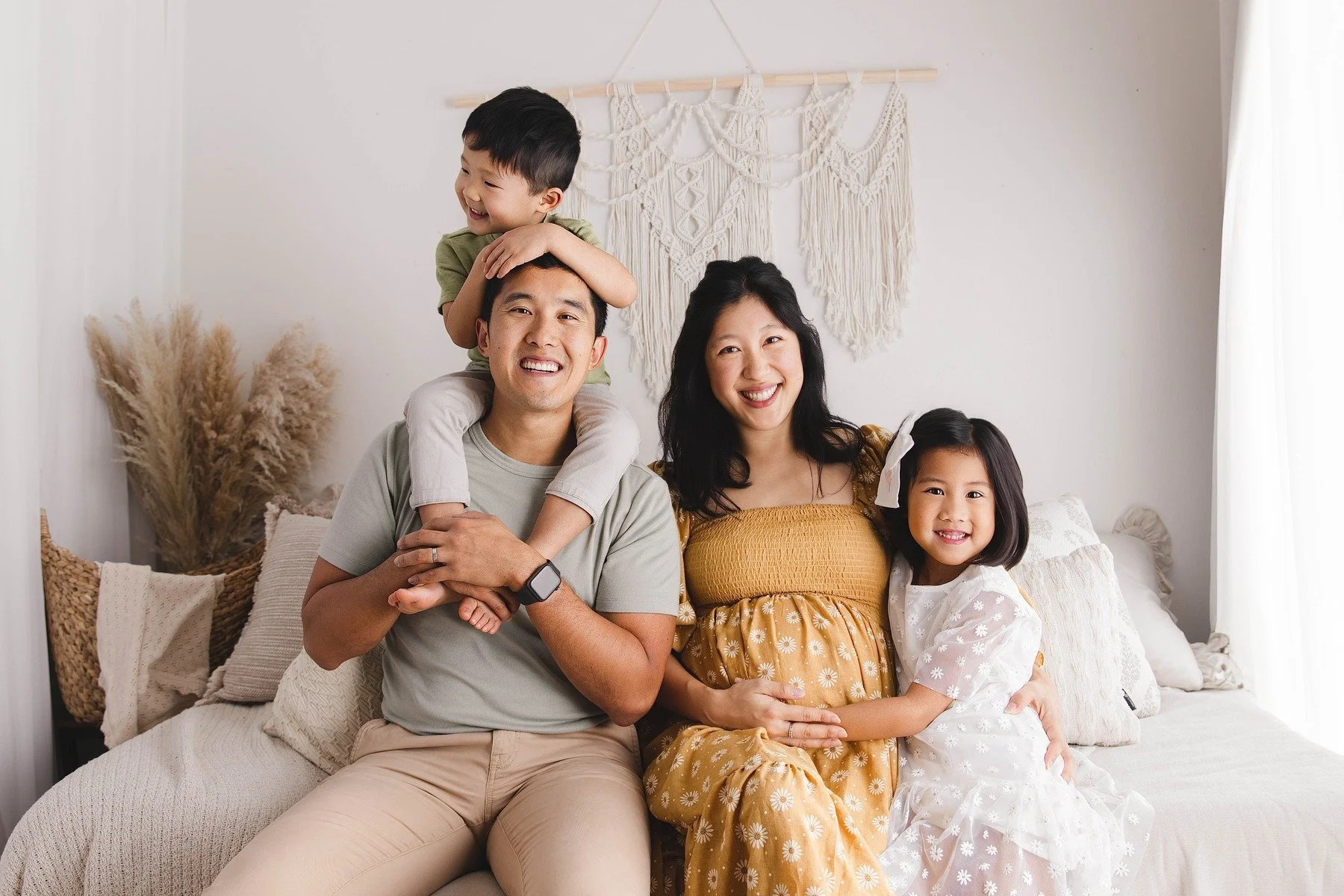 Lifestyle maternity photography in Allen, Texas: family portrait in a soft neutral studio, photographed by Manal Ansari