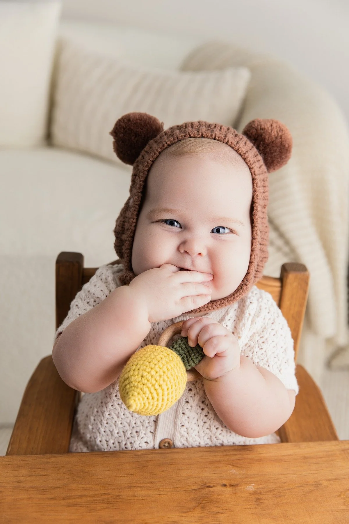 Paxton smiling and exploring a toy during his six-month milestone session