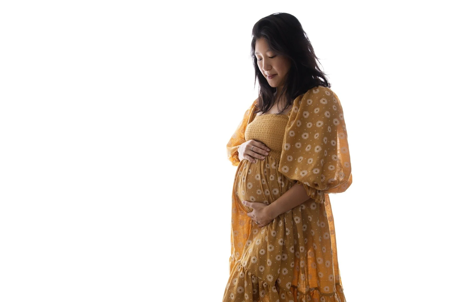 Lifestyle maternity photography in Allen, Texas: solo maternity portrait in a soft neutral studio, photographed by Manal Ansari