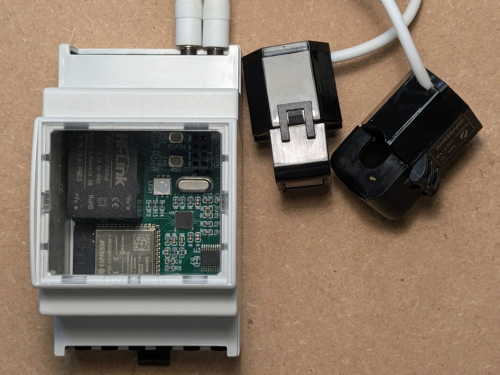 EnergyMe Home in its DIN rail enclosure with two current clamps