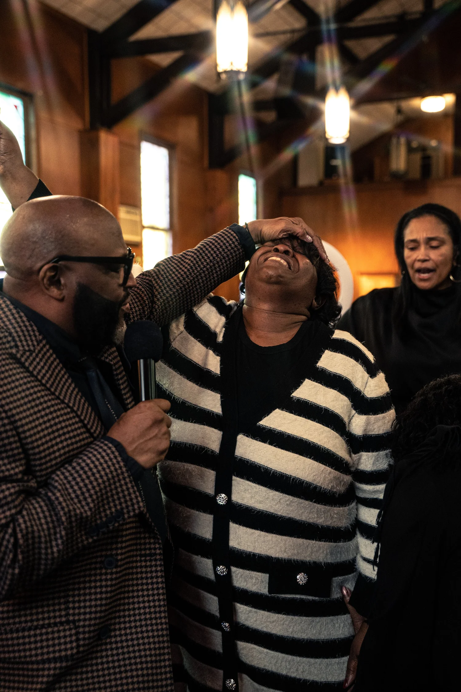 A minister prays over a worshipper as others worship during a service at LFT