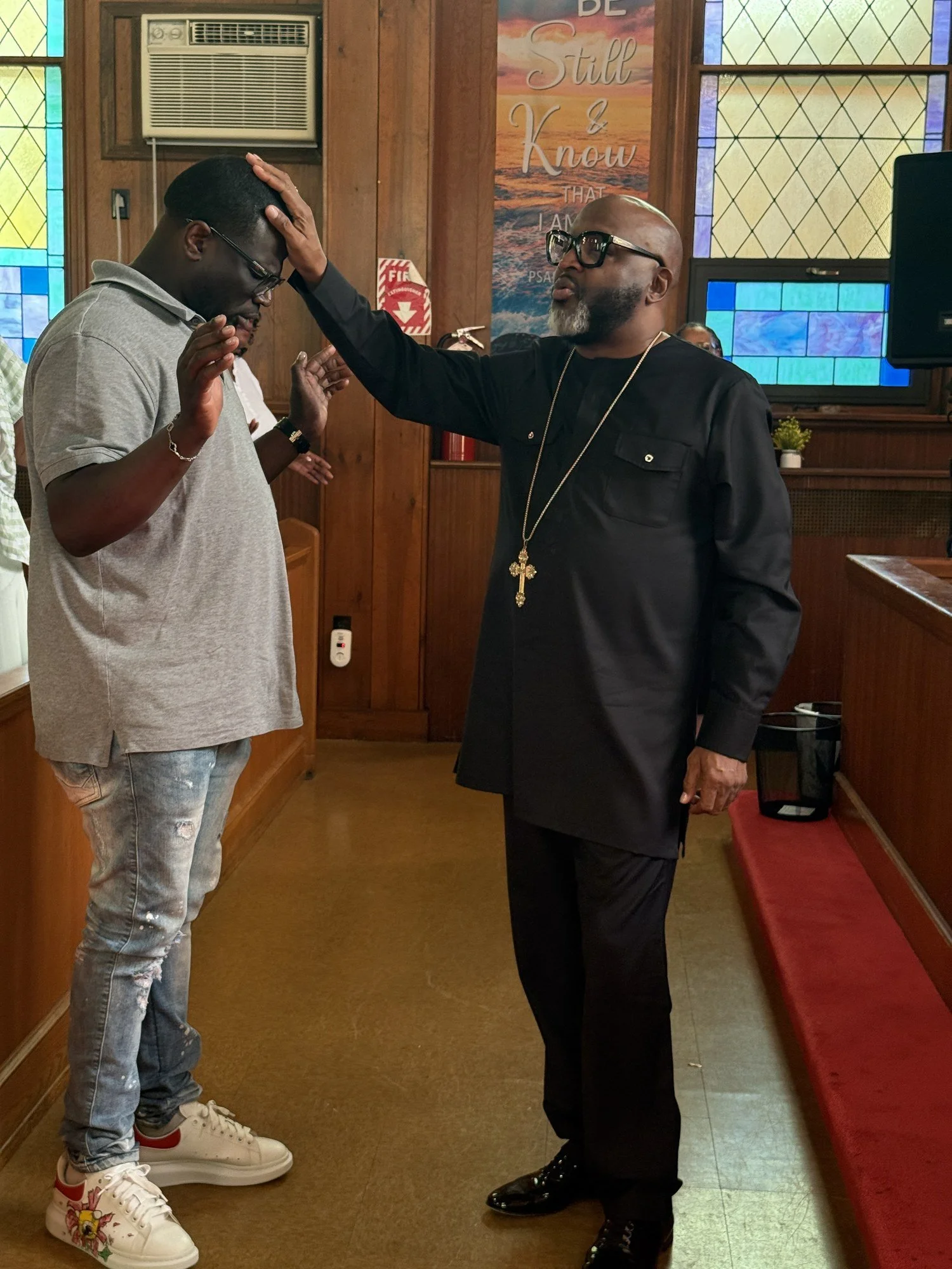 Bishop James H. Byrd praying over a man inside Love Fellowship Temple.
